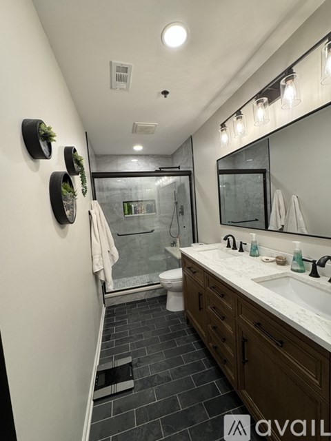 A bathroom with a sink, mirror, and a toilet.