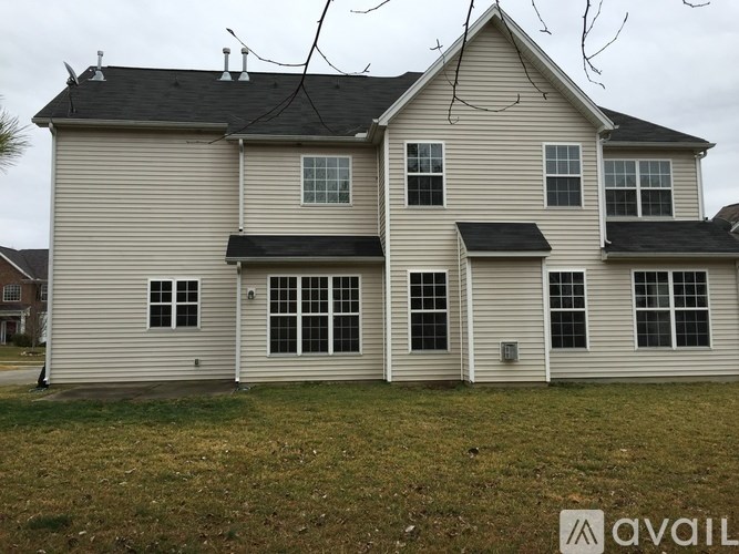 A two-story house with a grey roof and white siding.