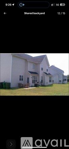 A white house with a black roof and a small porch.