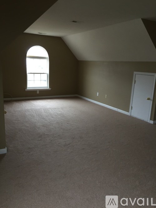 A large empty room with a window and a door.