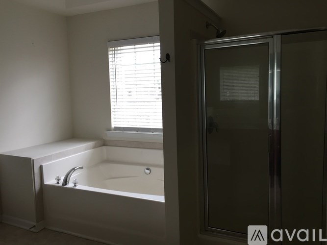 A bathroom with a tub and a shower stall.