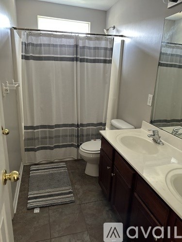 A bathroom with a toilet, sink, and shower curtain.