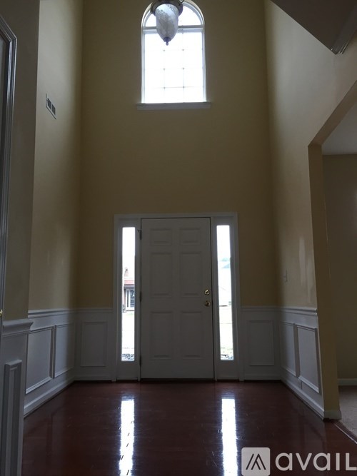 A room with a white door and a window above it.