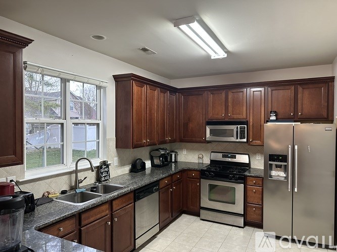 A kitchen with brown cabinets and stainless steel appliances.