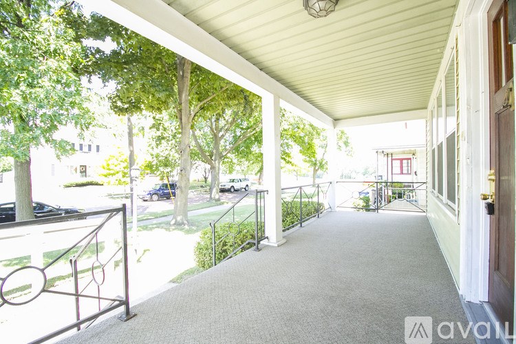 A balcony with a metal railing and a carpeted floor.