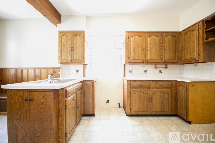 A kitchen with wooden cabinets and a white countertop.