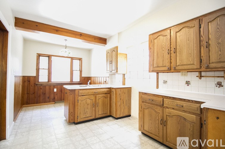 A kitchen with wooden cabinets and a tiled floor.