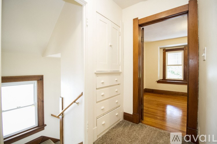 A room with a staircase and a door leading to another room.
