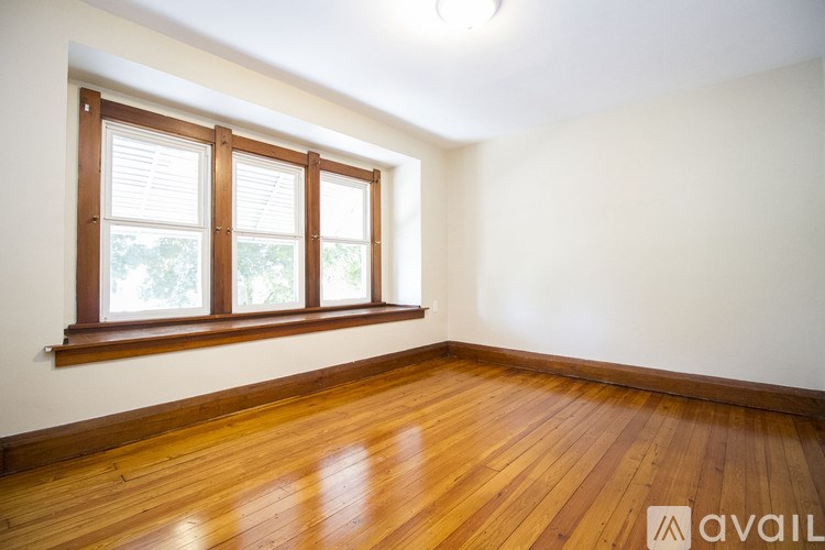 A room with wooden floors and a window with blinds.
