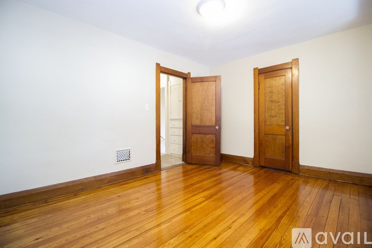 A room with wooden floors and two doors.