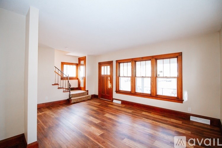 A room with wooden floors and a staircase.