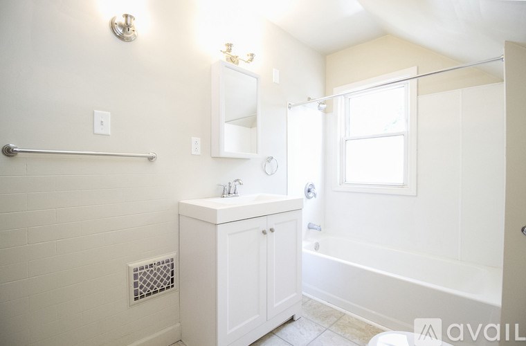 A white bathroom with a glass shower door and a white cabinet.