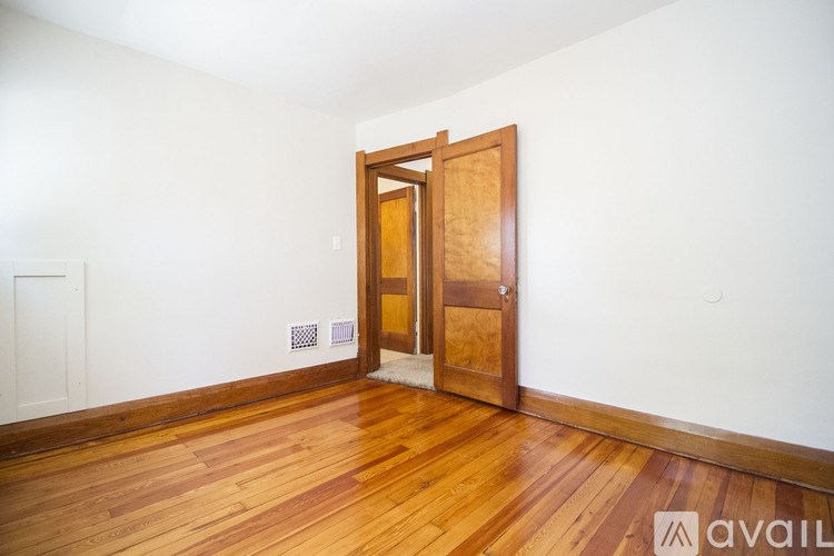 A room with a wooden floor and a wooden door.