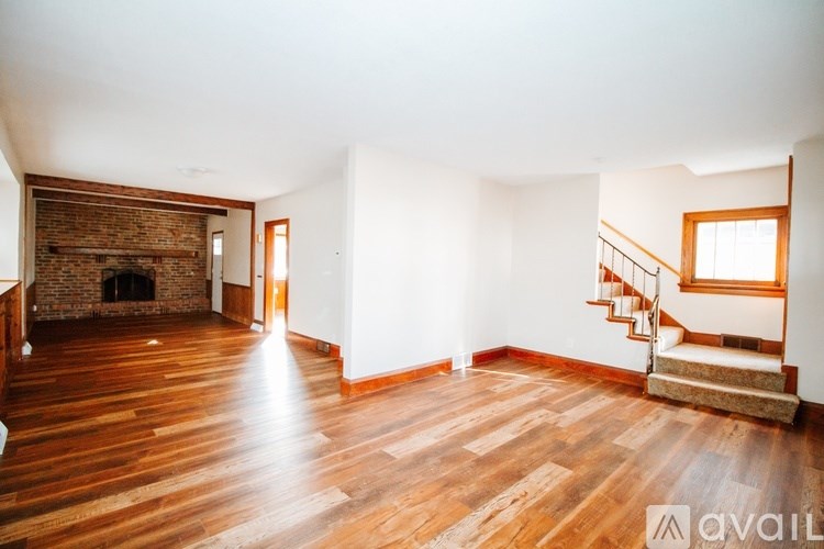 A room with wooden floors and a brick fireplace.