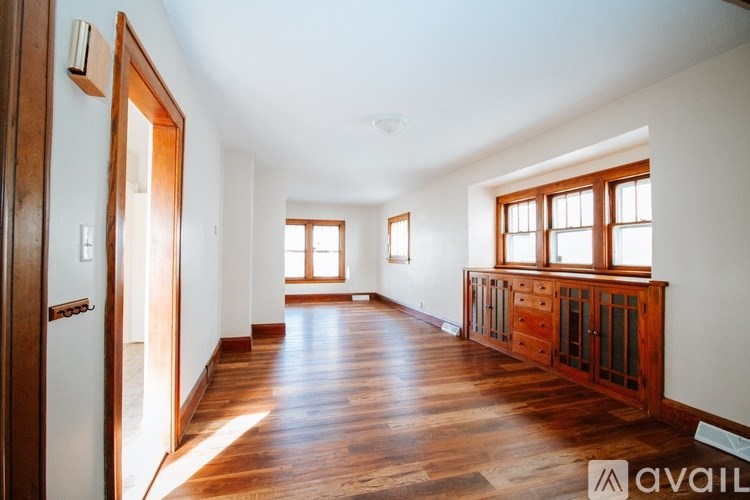 A spacious room with wooden floors and white walls.
