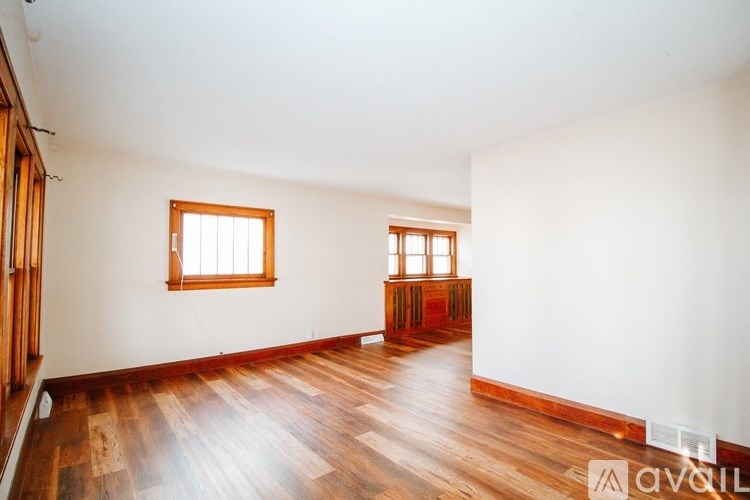 A room with wooden floors and two windows.
