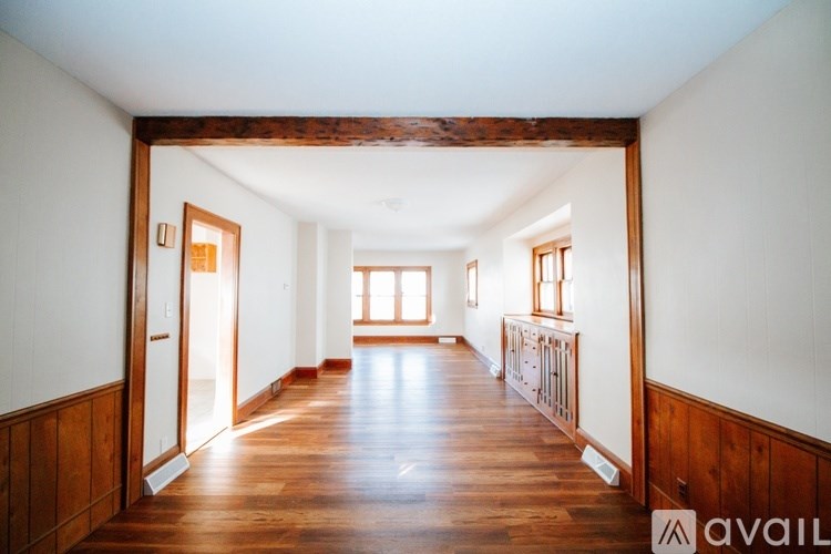 A long hallway with wood floors and white walls.
