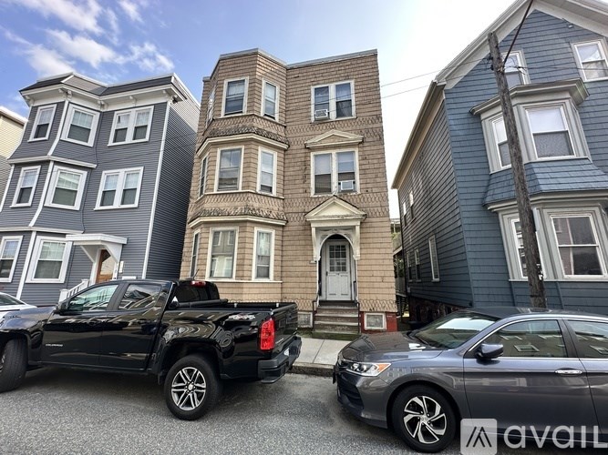 A black truck is parked in front of a two-story house.