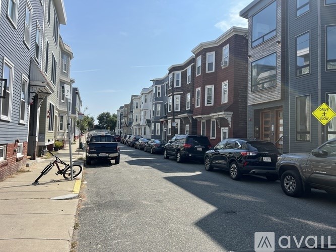 A street with parked cars and a bicycle on the sidewalk.