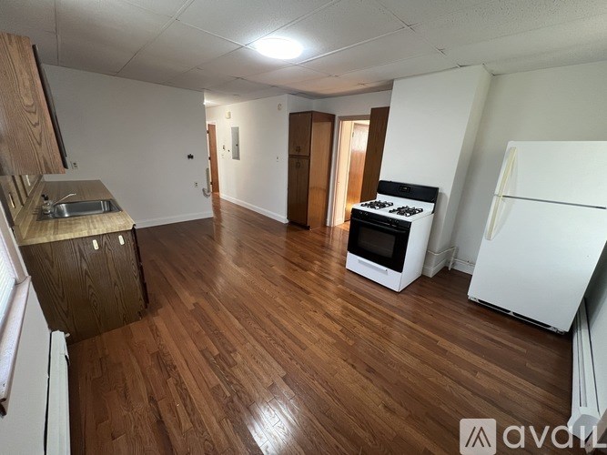 A kitchen area with a white fridge, white stove, and white oven.