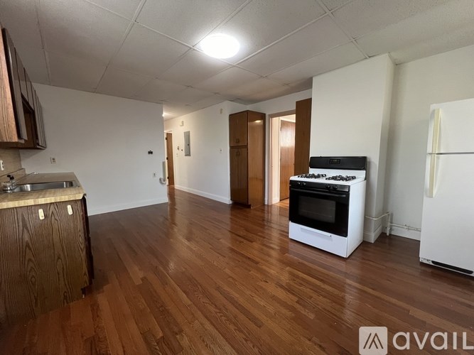 A kitchen with wooden floors and white appliances.