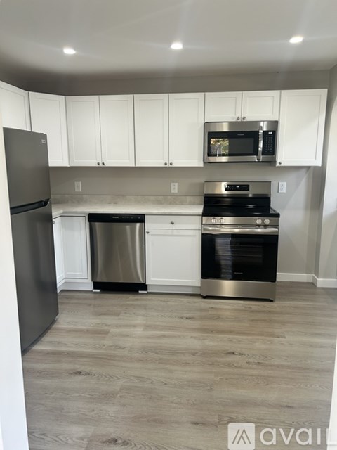 A kitchen with white cabinets and stainless steel appliances.