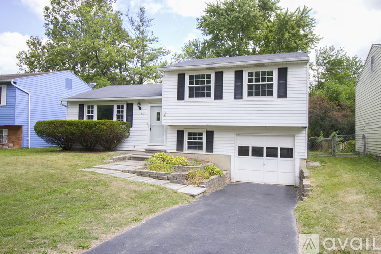 A two-story house with a garage and a driveway.