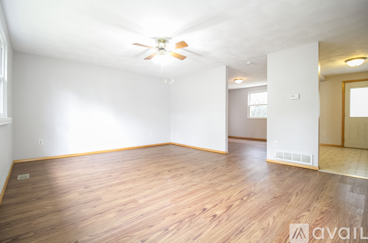 A room with wooden flooring and a ceiling fan.