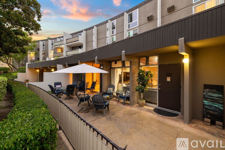 A modern building with a patio and chairs.