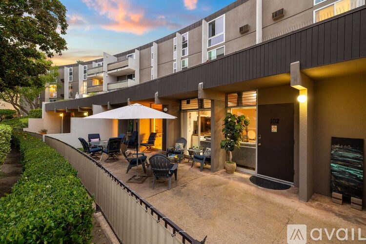 A modern building with a patio and chairs.