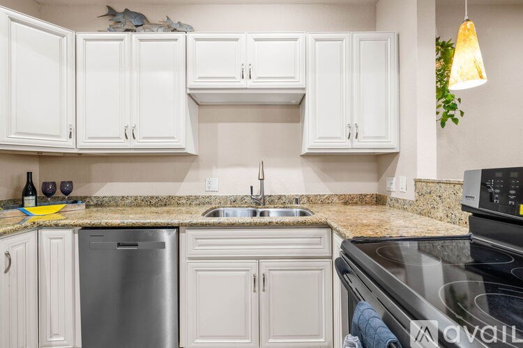 A kitchen with white cabinets and a granite countertop.