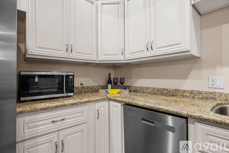 A kitchen with white cabinets and a granite countertop.