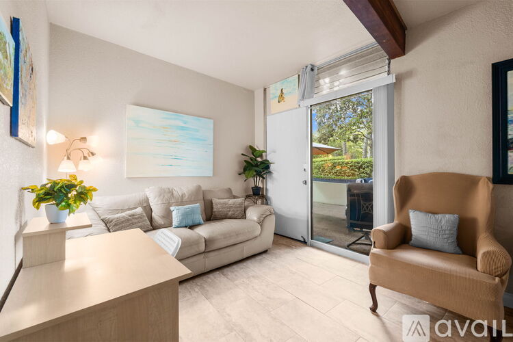 A living room with a couch, chair, and a painting on the wall.