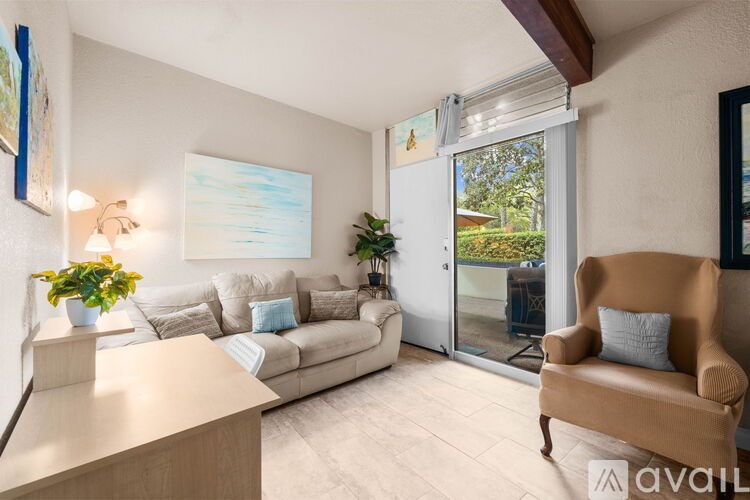 A living room with a couch, chair, and a painting on the wall.