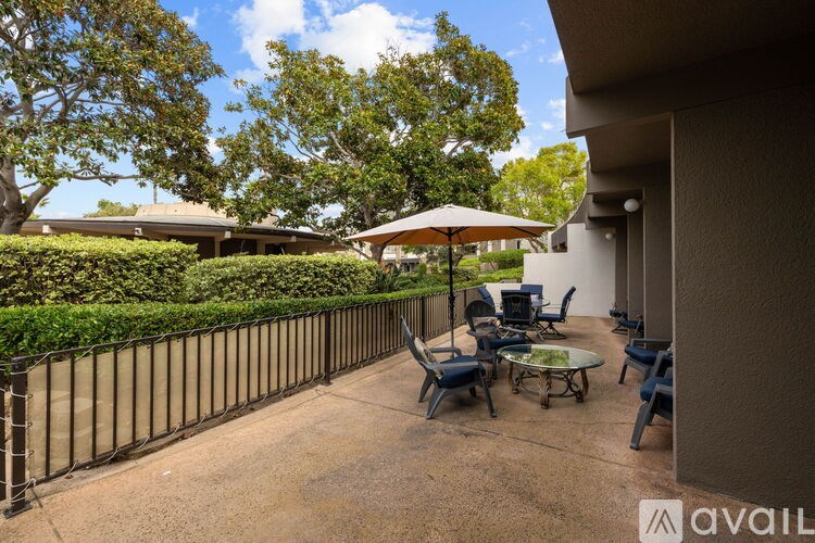 A patio with a table and chairs is surrounded by a fence.