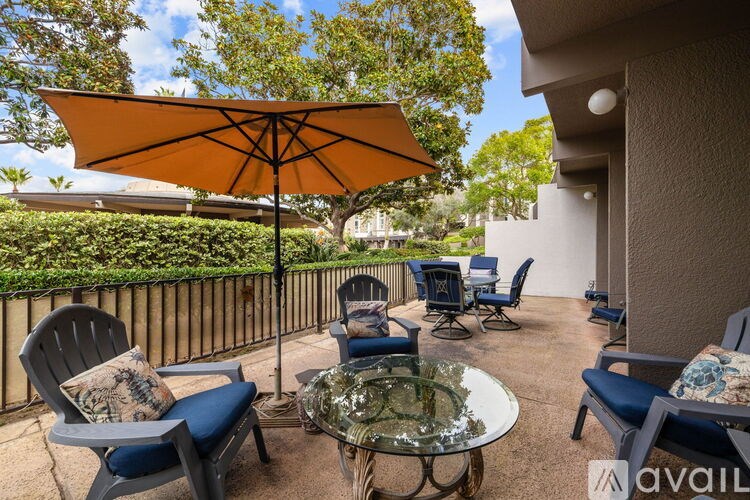 A patio with a table, chairs, and an umbrella.