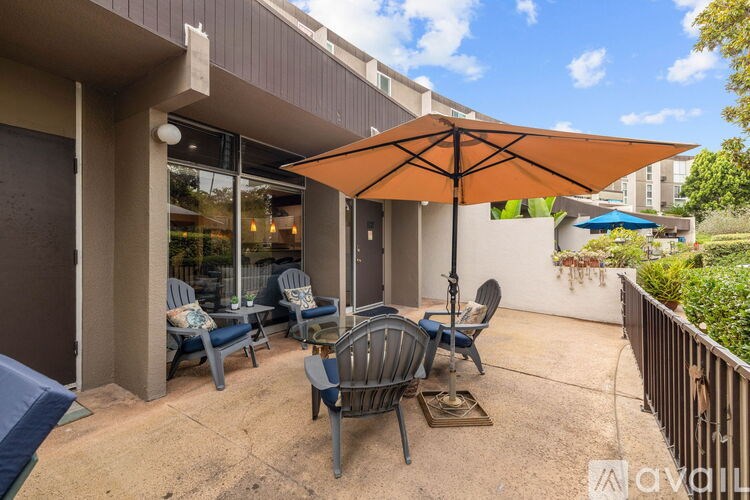 A patio with a table and chairs under an umbrella.
