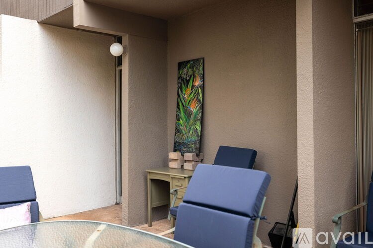 A room with a blue chair and a painting on the wall.