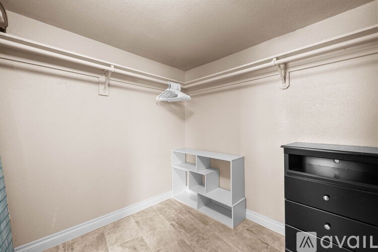 A room with a white ceiling, a grey shelf, and a black dresser.