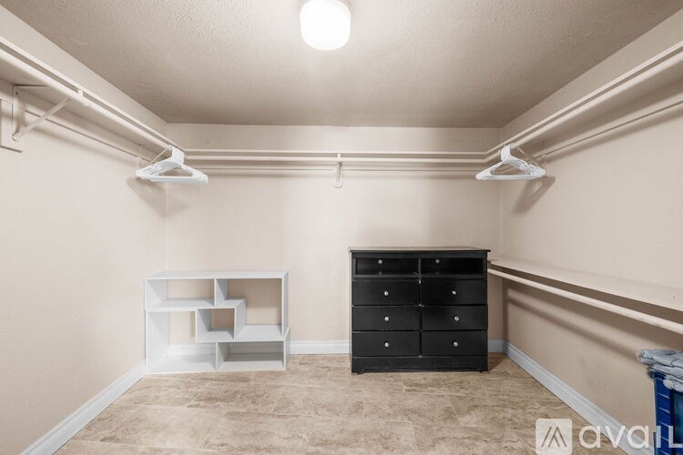 A room with a black dresser and a white shelf unit.