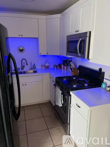 A kitchen with white cabinets and a black stove top.