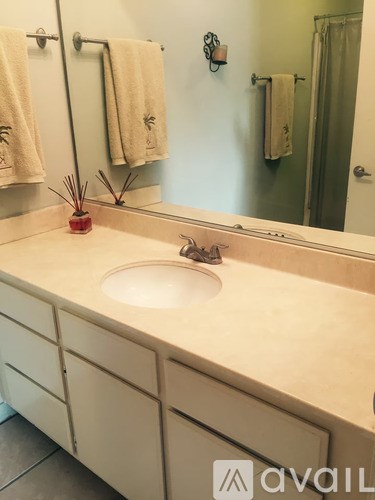 A bathroom with a sink and towel racks.