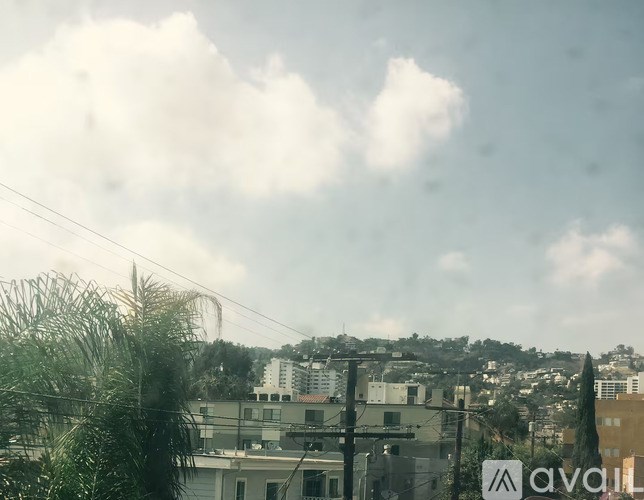 A view of a cityscape with buildings and trees in the foreground.