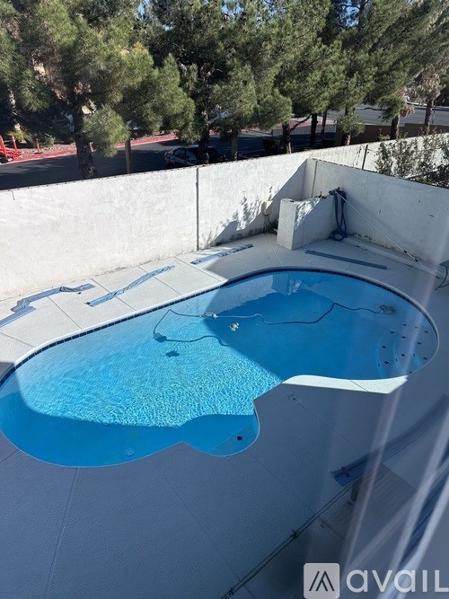 A hot tub sits on a patio with trees in the background.