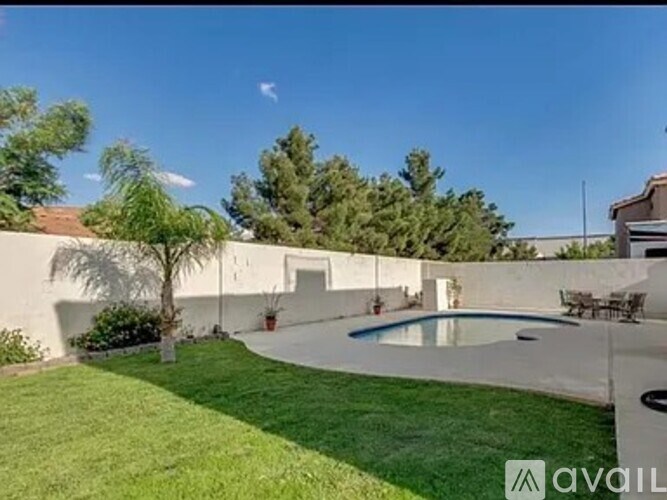 A backyard with a pool and a patio table.