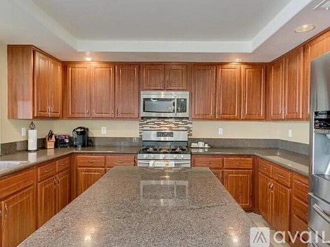 A kitchen with wooden cabinets and granite countertops.