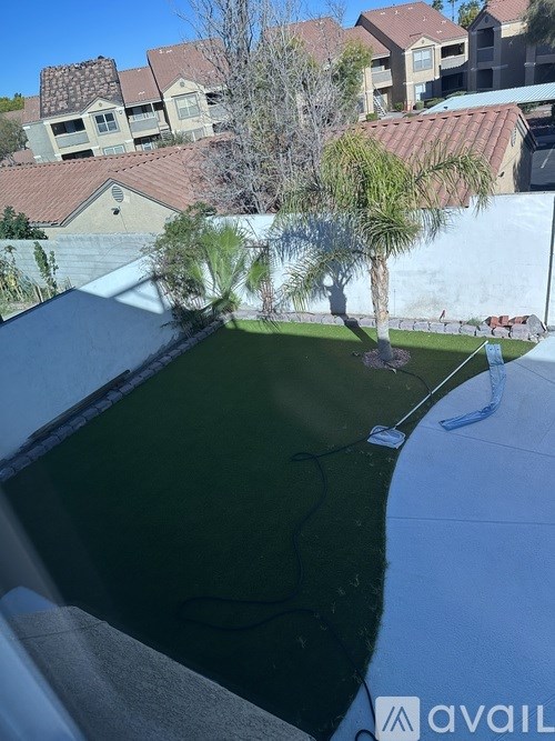 A view from a balcony overlooking a pool and a residential area.