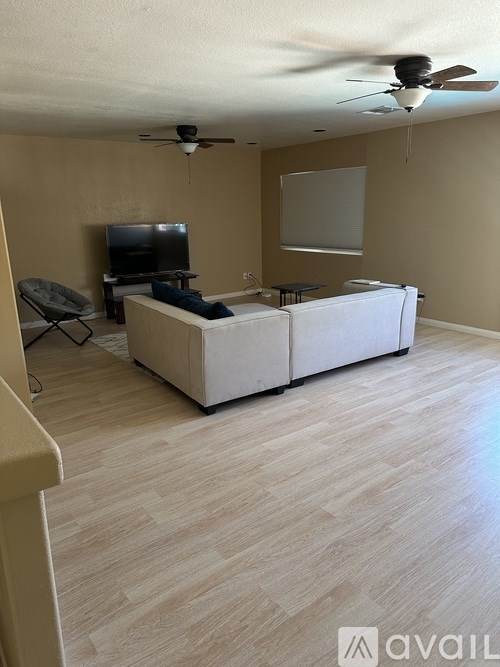 A living room with a television, a couch, and a chair.