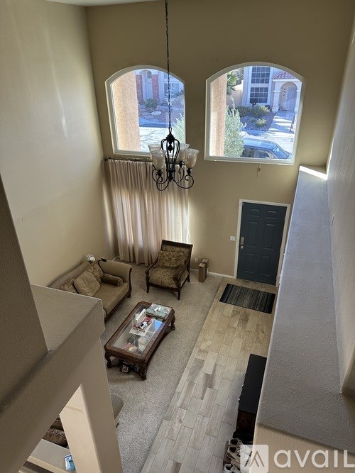 A living room with a couch, a coffee table, and a chandelier.
