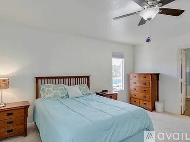 A bedroom with a bed, nightstand, and dresser.